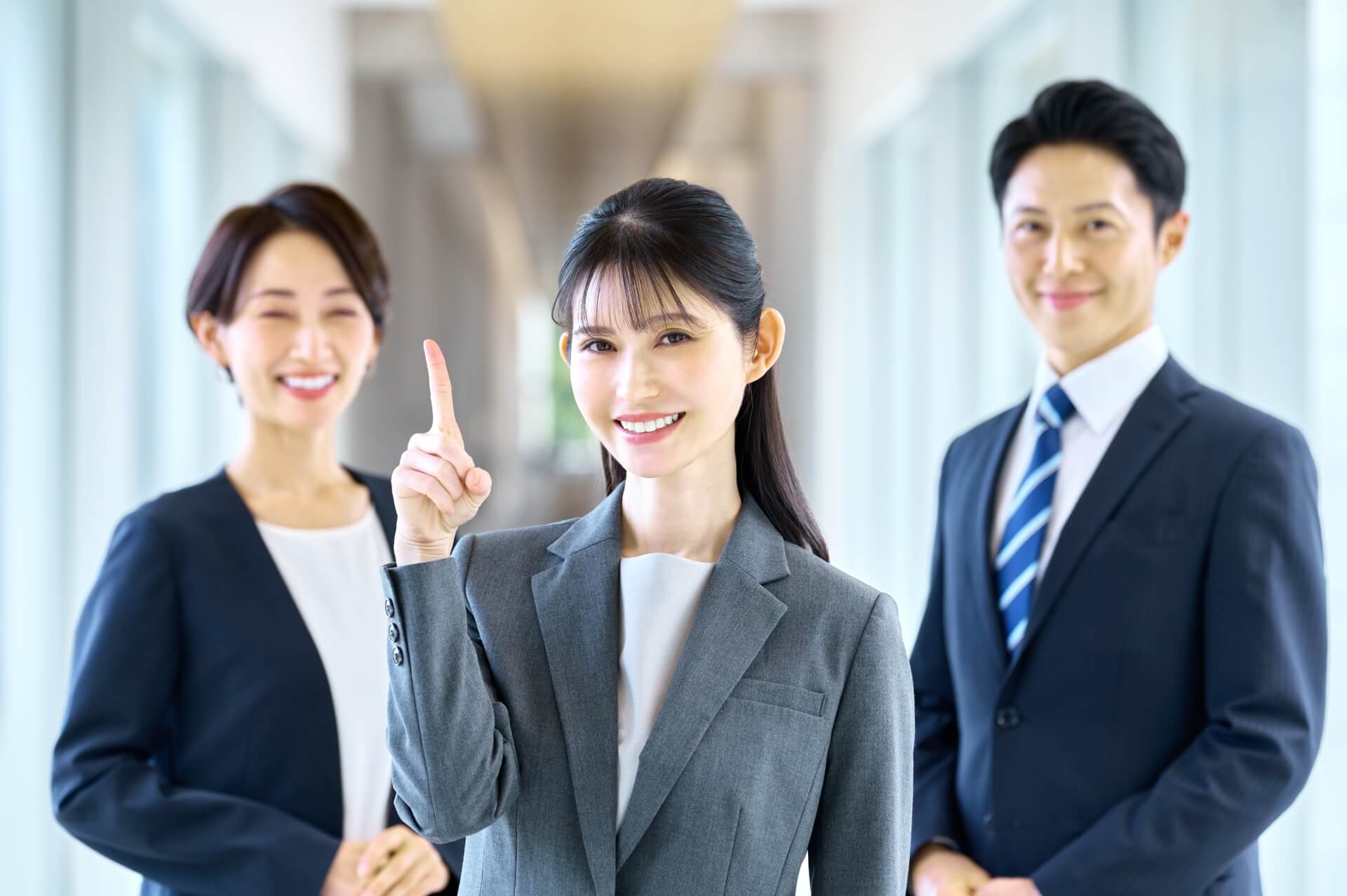 オフィスでポーズをとる三人のビジネスパーソン